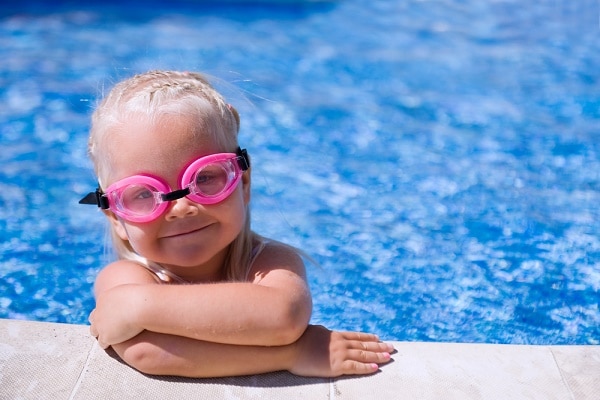 girl swimming in pool with goggles on