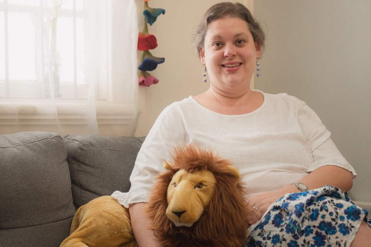 Blooming Heart Therapy staff sitting with stuffed lion toy.