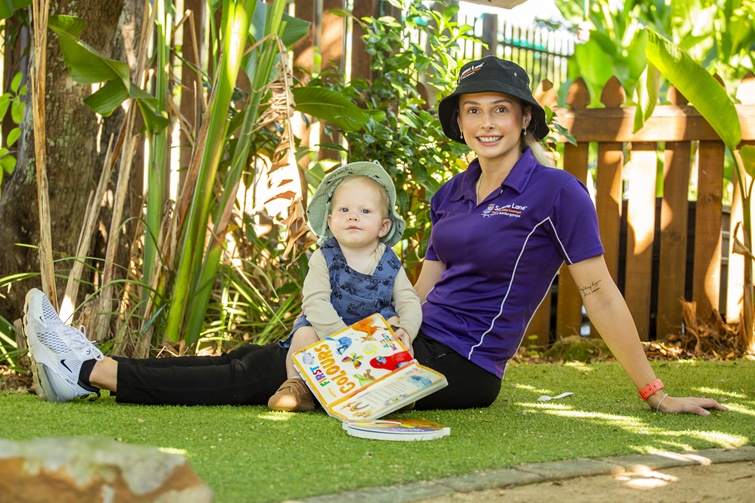 childcare working sitting with child at sesame lane.