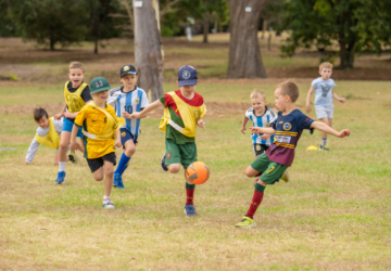 Q Kids Sport happy kids kicking a ball.