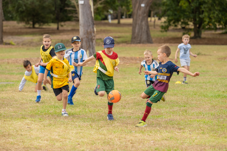 Q Kids Sport happy kids kicking a ball.