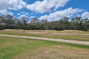 Grassed area with BMX jumps at Crestmead Park.