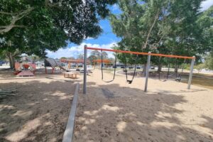 Bank of swings with sand base at Crestmead Park.
