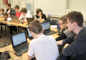 The Lab participants and mentor with laptops at table.