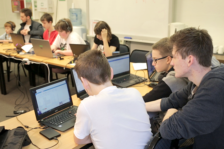 The Lab participants and mentor with laptops at table.