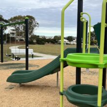 Swings, slide, and climbing rings at Grandview Place Park.