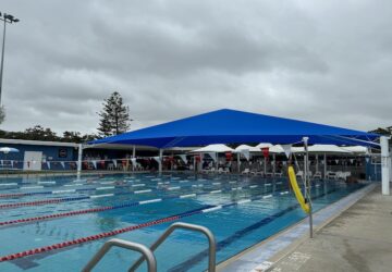 Outdoor eight lane pool with partial shade sails at Manly Pool.