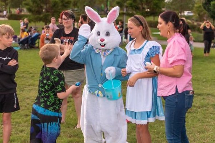 Easter Bunny meeting kids at the Everleigh Easter movie night.