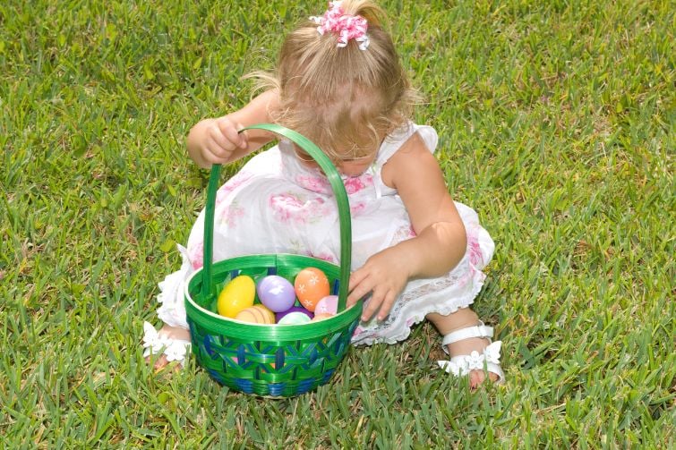 Girl with a basket full of Easter egss.