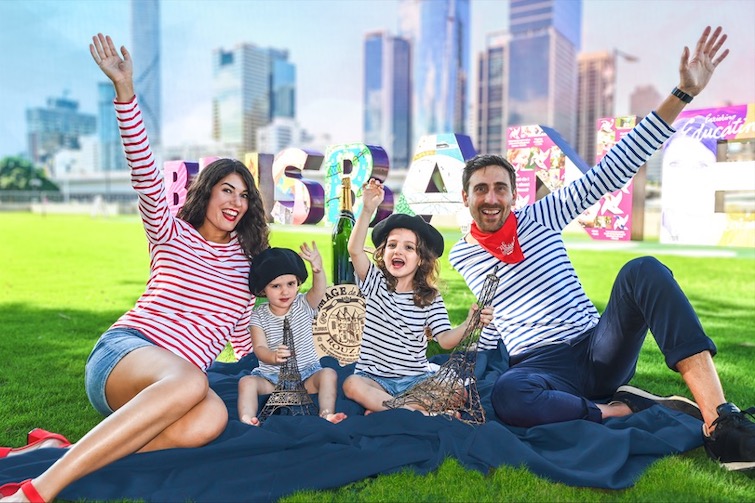 Le-french-festival brisbane event image of family in red, blue and white in front of the Brisbane sign.