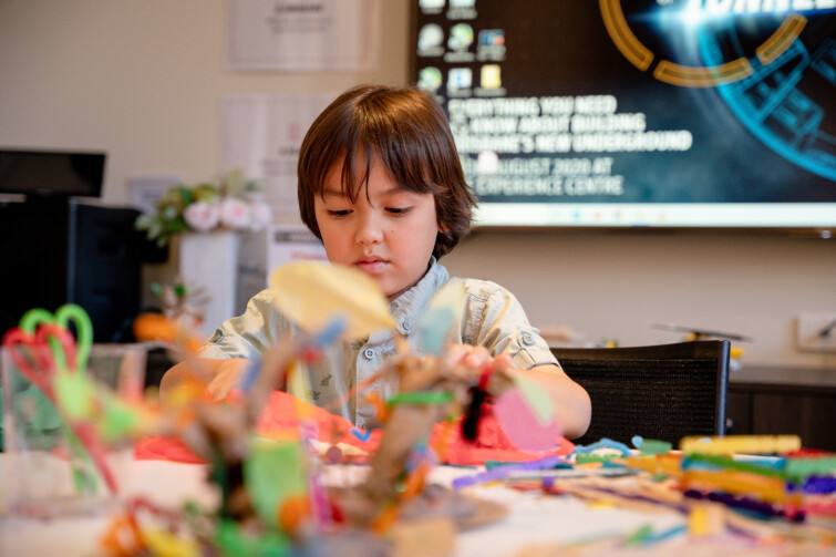 Cross River Rail Experience Holiday program event image of child cutting craft.