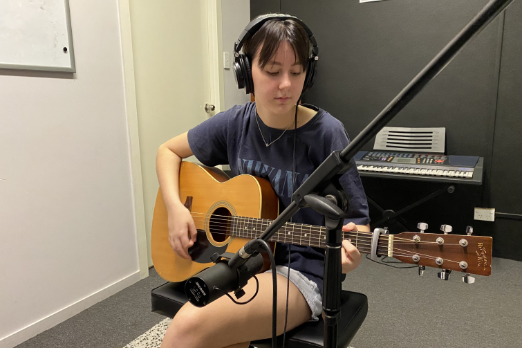 Downtown Creative Studios child in recording studio with guitar.