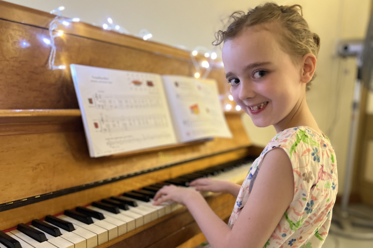 Downtown Creative Studios child sitting at piano.