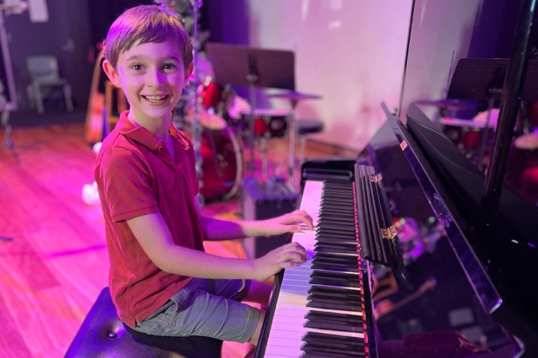 Downtown Creative Studios child smiling at piano.