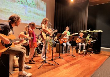 Downtown Creative Studios children on stage playing guitars.