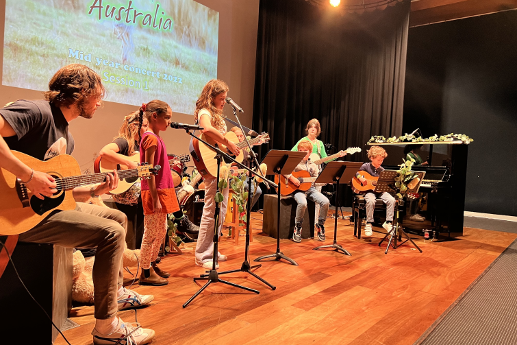 Downtown Creative Studios children on stage playing guitars.