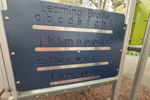 Learning braille play panel at Brennan Park.
