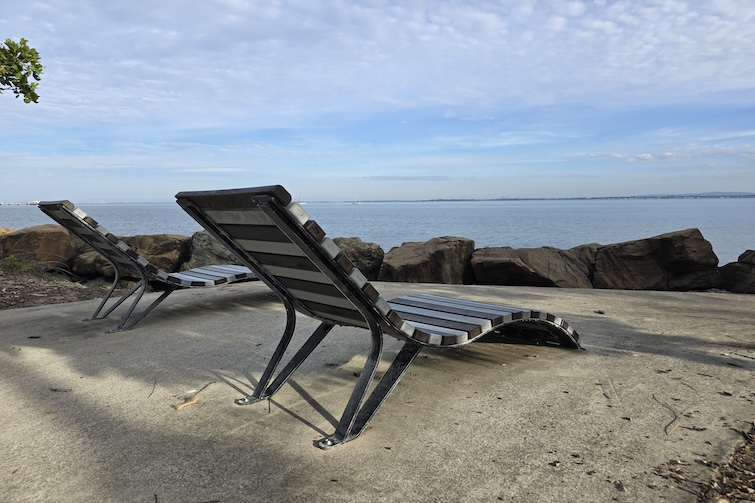 Two sun lounges by the water beside Redcliffe Parkour Park.