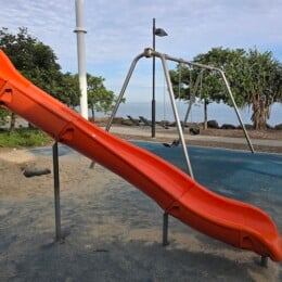 Slide and swings at playground beside Redcliffe Parkour Park.