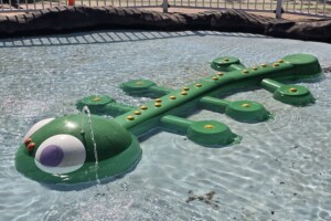 Green crocodile with water spout in toddler water play area at Settlement Cove Lagoon in Redcliffe.