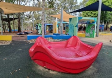 Red roundabout in the playground at Upper Kedron Recreation Reserve.