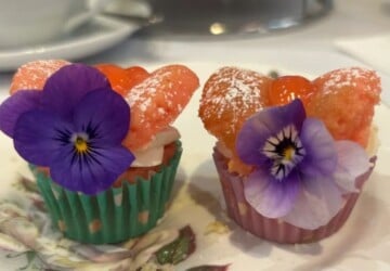 Two cupcakes with edible flowers on them at Room with Roses in the Brisbane Arcade.