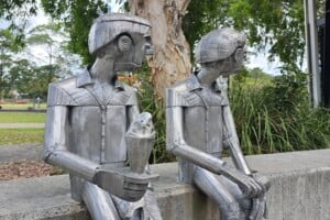 Two metal statues of men eating ice cream at Frew Park.