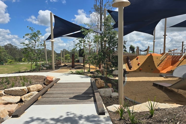 Wooden bridge and playground at Glider Park in Morayfield.