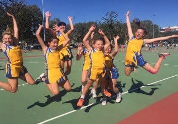 Aspley Devils Netball Club players jumping in the air.