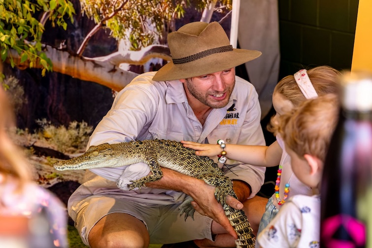 Man holding baby crocodile for kids entertainment at Mansfield Tavern.