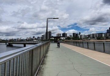 Person riding a bike along the Brisbane Riverwalk.