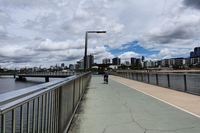 Person riding a bike along the Brisbane Riverwalk.
