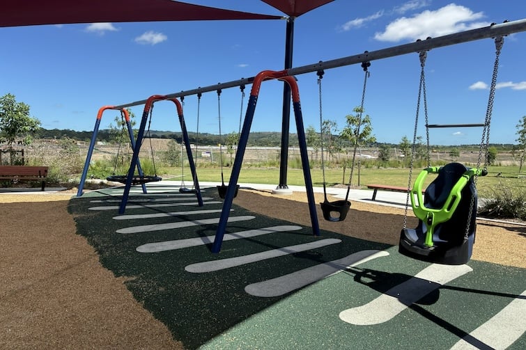 Bank of swings including high back swing with harness at Daybreak Park, Walloon.