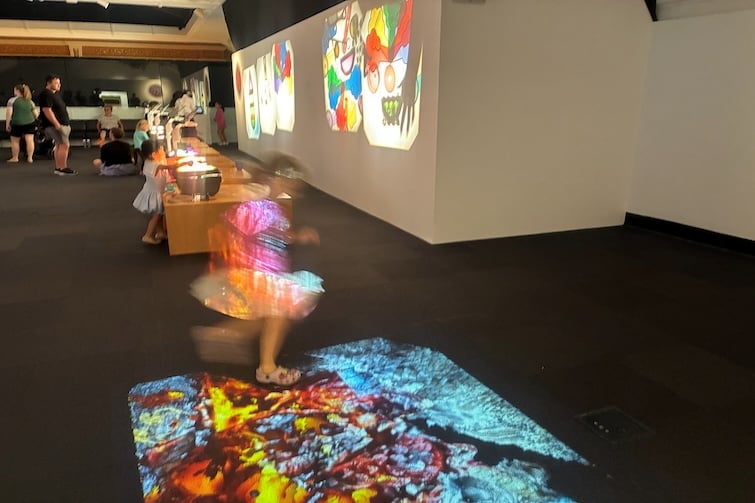 Girl dancing on interactive floor display at LightPlay, Ipswich Art Gallery.