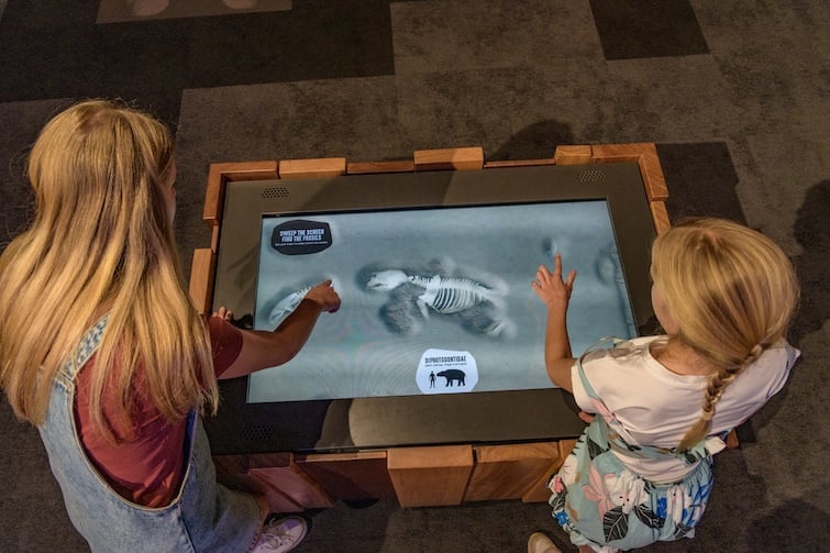 Two children using a touch screen at Riversleigh Fossil Discovery Centre.