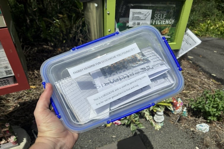 A person holding a geocaching box.