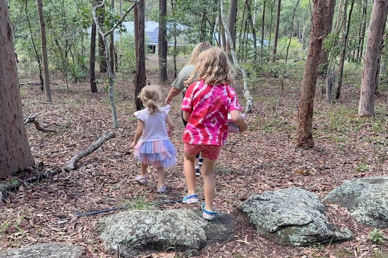 A family walking through the bush at Moggill search for a geocache.