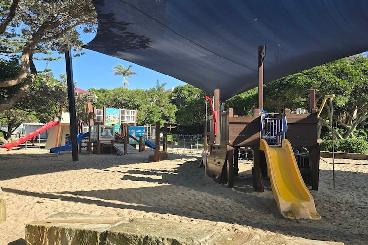 Slide and wooden pirate ship under shade sail at Happy Valley Playground in Caloundra.