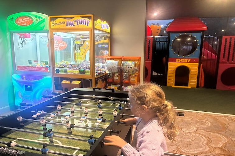 A child playing foosball in the games room at Bellbowrie Tavern.
