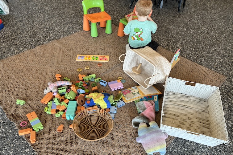 A child sitting on a mat playing with toys at Chapters Book Shop Cafe, Karalee.