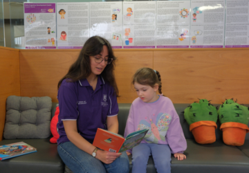 UQ Early Cognitive Development Centre staff reading with young girl.
