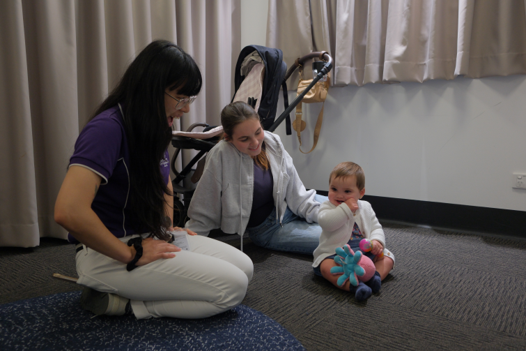 UQ Early Cognitive Development Centre staff with mother and baby.