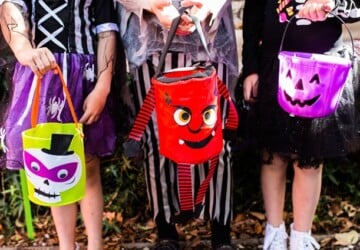 kids in halloween costumes carrying halloween baskets