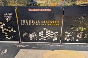Fence and sign at The Hills District All Abilities Park.