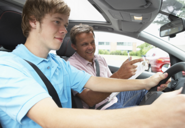 teenager learning to drive next to an instructor.